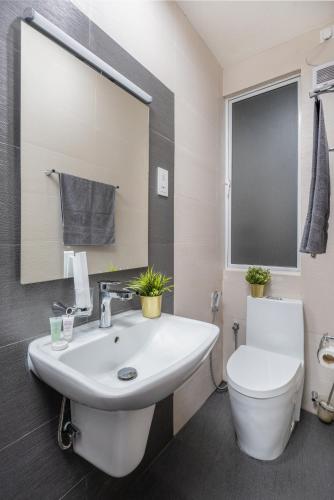 a bathroom with a white sink and a toilet at The Alfred Fern - Modern 2-Bedroom Apartment with Pool in Prime Colombo 3 in Colombo