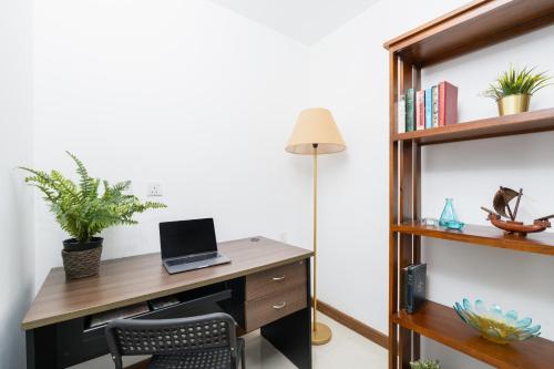an office with a desk with a laptop and a lamp at The Alfred Fern - Modern 2-Bedroom Apartment with Pool in Prime Colombo 3 in Colombo
