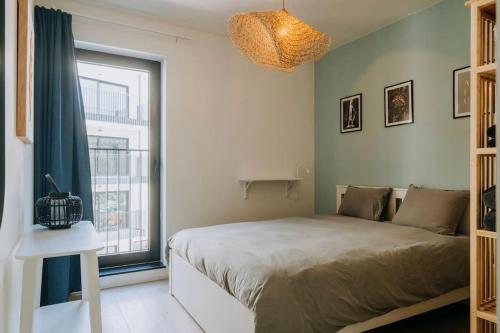a bedroom with a bed and a large window at 2 bedroom apartment and private parking in Liège center in Liège
