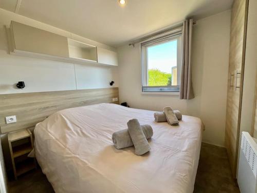 une chambre avec un lit avec deux serviettes dessus dans l'établissement Bungalow neuf avec belle terrasse couverte et piscine, à Corcieux