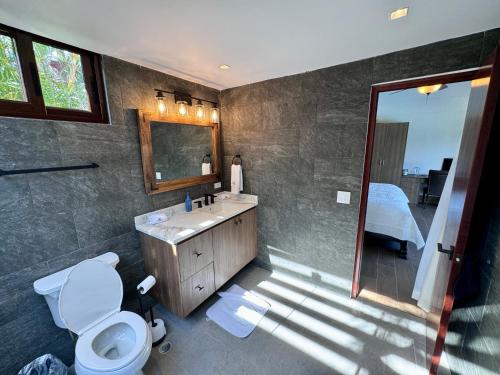 a bathroom with a toilet and a sink and a mirror at Villa Solara 6 - Luxury 6 Bedroom Villa with Pool, Golf & Lake View in Río Hato