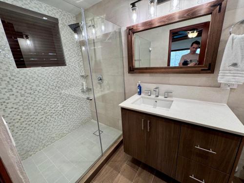 a bathroom with a shower and a sink and a mirror at Villa Solara 6 - Luxury 6 Bedroom Villa with Pool, Golf & Lake View in Río Hato