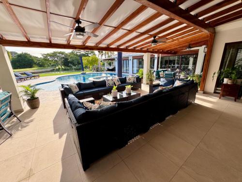 a living room with a large couch on a patio at Villa Solara 6 - Luxury 6 Bedroom Villa with Pool, Golf & Lake View in Río Hato