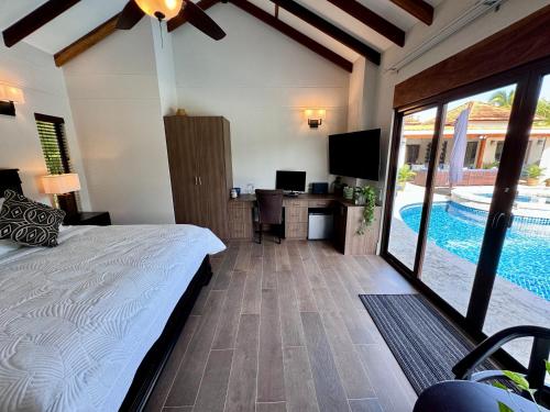 a bedroom with a bed and a desk and a pool at Villa Solara 6 - Luxury 6 Bedroom Villa with Pool, Golf & Lake View in Río Hato
