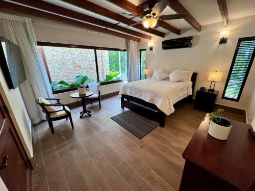 a bedroom with a bed and a desk and a window at Villa Solara 6 - Luxury 6 Bedroom Villa with Pool, Golf & Lake View in Río Hato