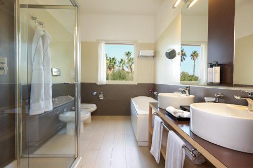 a bathroom with a sink and a toilet and a shower at Almar Timi Ama Resort & Spa in Villasimius