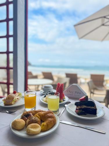 a table with plates of food and glasses of orange juice at Chez Pitu Praia Hotel in Búzios