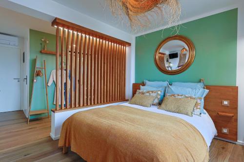 a bedroom with a large bed and a mirror at chambre d'hote luxe vue mer boheme in Le Pradet