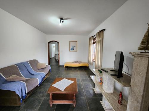 a living room with a couch and a tv at Casa Peruibe frente a praia in Peruíbe