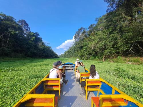 a group of people riding a boat down a river at Jacamar Lodge Expeditions in Iquitos