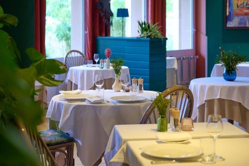 a restaurant with two tables with white table cloths at Logis L'Ermitage Hôtel & Restaurant in Saulges