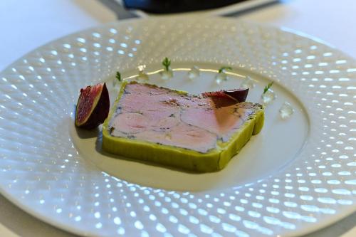 a white plate with a piece of food on it at Logis L'Ermitage Hôtel & Restaurant in Saulges