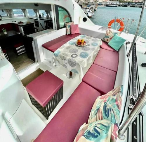 a table on the back of a boat with pink seats at Centro Ibiza Catamaranes y Velero in Ibiza Town