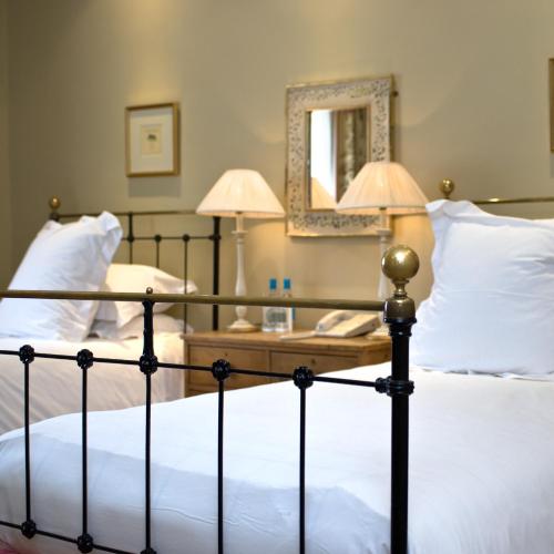 a bedroom with two beds and a mirror at The Old Bridge in Huntingdon