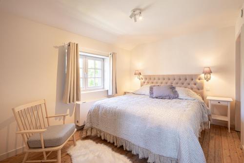 a bedroom with a bed and a chair and a window at Villa Cocquelicot 6p in De Panne