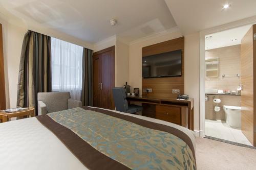 a hotel room with a bed and a bathroom at Thistle London Piccadilly in London