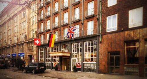 a building with flags on the side of a street at Hotel Baseler Hof in Hamburg