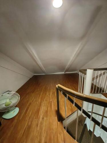 an attic room with a staircase and a wooden floor at Cozy Townhouse own parking Wi-Fi in Baguio
