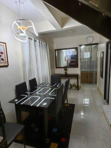 a dining room with a black table and chairs at Cozy Townhouse own parking Wi-Fi in Baguio