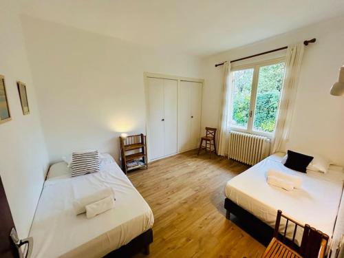 une chambre avec deux lits et une fenêtre dans l'établissement Villa6pers,Moulleau,2minpiedplage,jardin,parking,wifi, à Arcachon