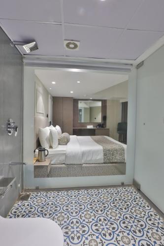 a hotel room with a bed and a bathroom at Hotel The Grand Suites in Ahmedabad