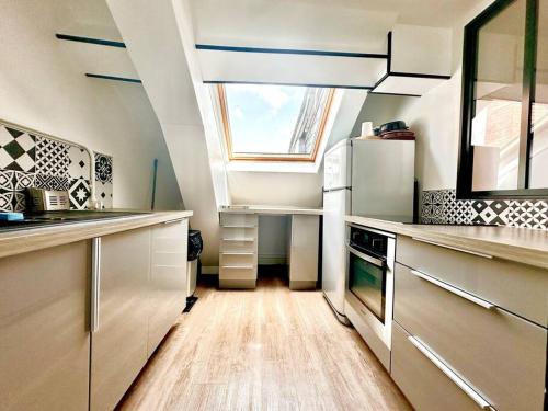 une cuisine avec une lucarne et une fenêtre dans l'établissement L'appartement en bord de Loire de Quentin & Manon, à Sully-sur-Loire