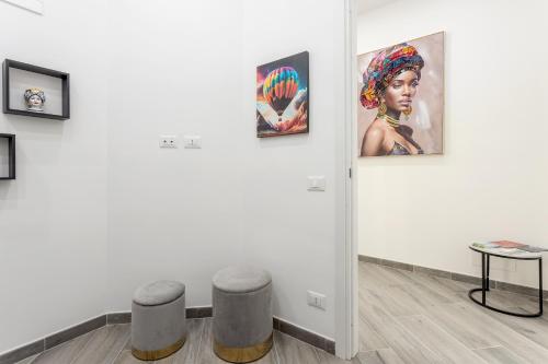 a room with two stools and paintings on a wall at Sant'Erasmo luxury home in Palermo