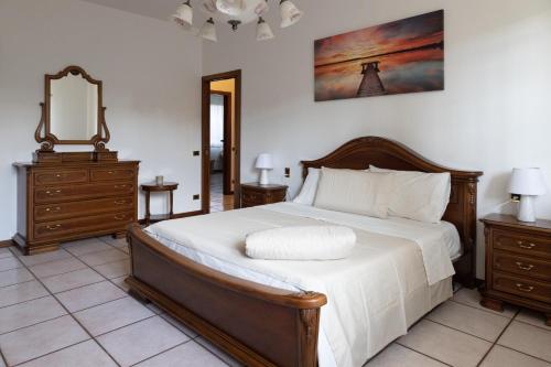 a bedroom with a bed with white sheets and a mirror at Appartamento in villa "Casa Adele" in Cenate Sotto