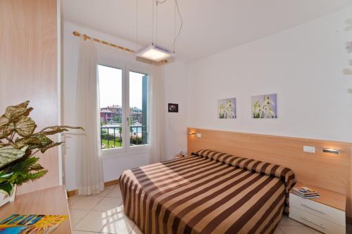 a bedroom with a bed and a large window at Villaggio Sant'Andrea in Caorle