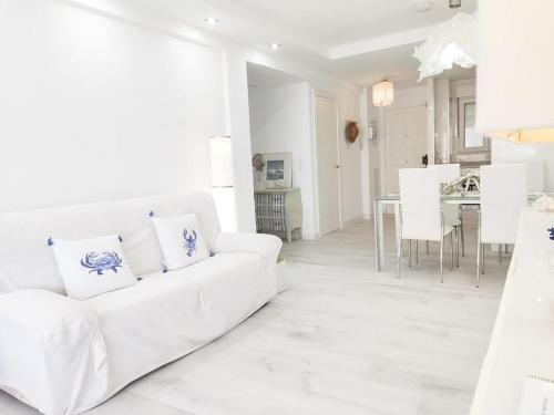 een witte woonkamer met een witte bank en een tafel bij QBF Quality Beachfront in Torre del Mar