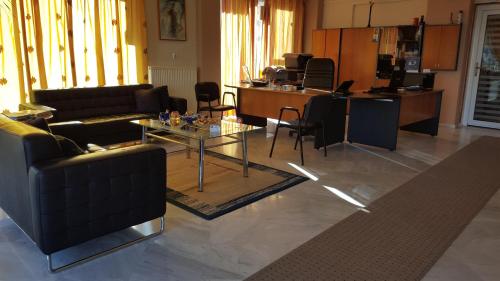 a living room with couches and a table and chairs at Stella Family Apartments in Síndos