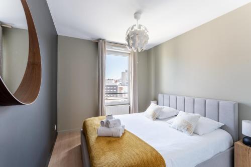 une chambre avec un lit blanc avec une grande fenêtre dans l'établissement MDOR - Montagari Appt à Lyon, à Lyon