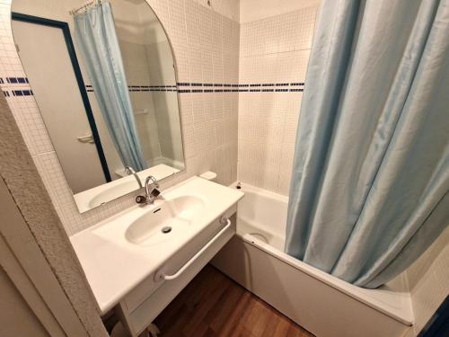 une salle de bain avec un lavabo et un rideau de douche dans l'établissement Studio 4 pers au coeur de Valfréjus avec balcon, cuisine équipée, casier à skis - FR-1-265-255, à Valfréjus