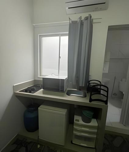 a kitchen counter with a sink and a window at Residencial JC II sua casa em Belém do Pará in Belém