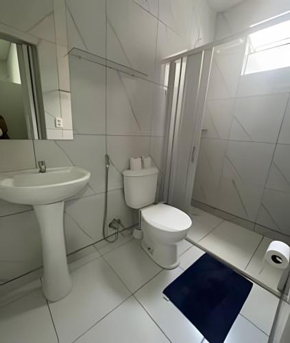 a white bathroom with a toilet and a sink at Residencial JC II sua casa em Belém do Pará in Belém