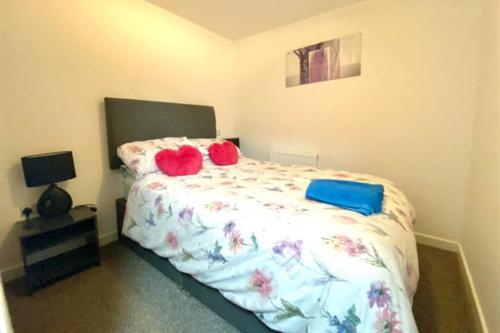 a bedroom with a bed with two red pillows on it at Cosy Nook - Town centre flat with free nearby parking, in Shrewsbury