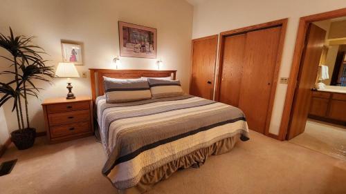 a bedroom with a bed and a lamp and a plant at Southridge #20 in Harbor Springs