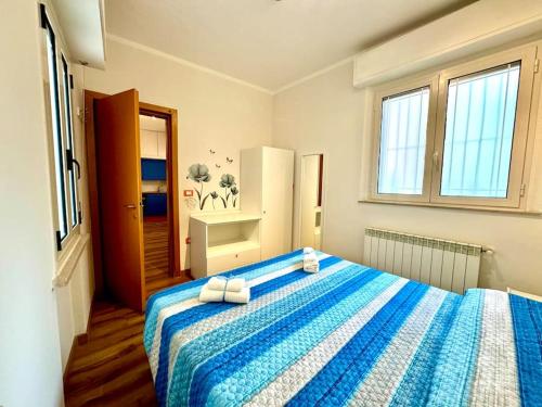 Un dormitorio con una cama azul y blanca con toallas. en B&B Mare Salotto, en Pescara