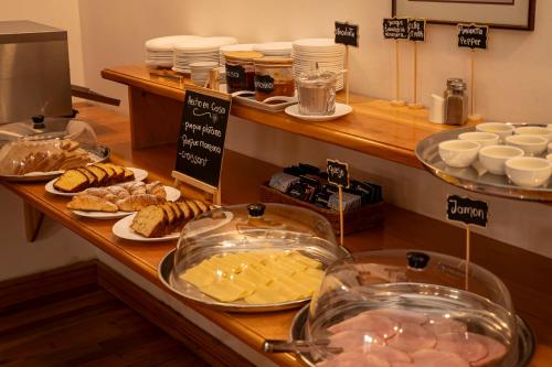 a buffet with cheese and other food on a counter at Hotel Plaza in Punta Arenas