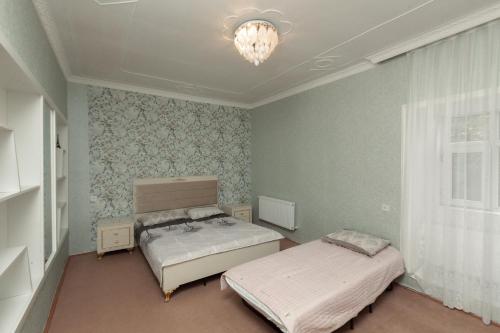a bedroom with two beds and a chandelier at Cozy Home Gabala in Gabala