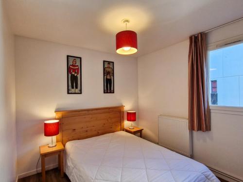 une chambre avec un lit avec deux lampes et une fenêtre dans l'établissement Appartement spacieux à Flaine Forêt · Balcon Sud · Parking couvert · Proche pistes et commerces - FR-1-425-124, à Flaine