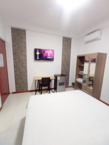 a room with a bed and a tv on the wall at Deluxe Hotel Talara in Talara