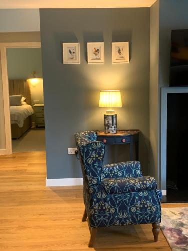 a living room with a chair and a lamp at 1 Beechwood at Thoulstone Park in Westbury