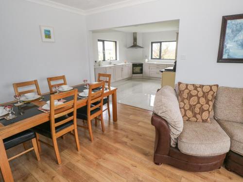 a kitchen and dining room with a table and a couch at Country Bungalow in Boyle