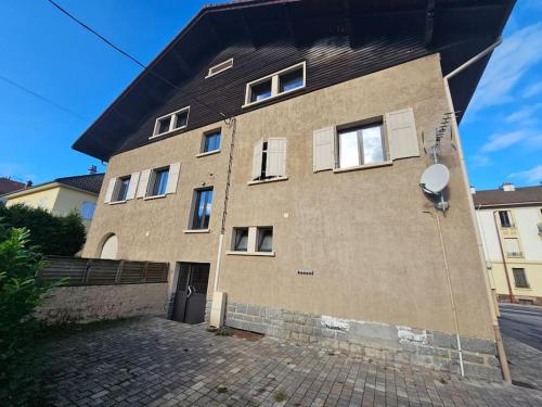 un grand bâtiment en briques avec un toit noir dans l'établissement Le tout en double, à Gérardmer