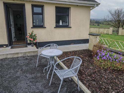 two chairs and a table in front of a house at Country Bungalow in Boyle