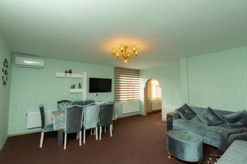 a living room with a couch and a table and chairs at Cozy Home Gabala in Gabala