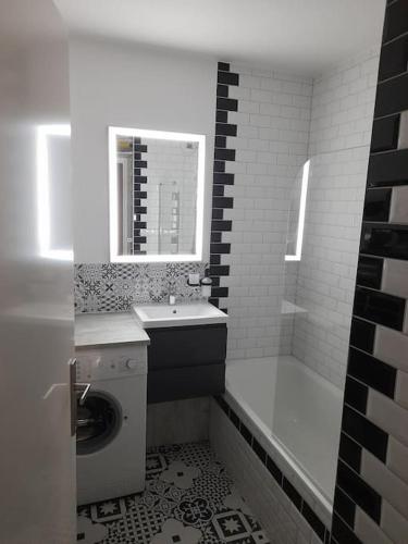 La salle de bains blanche est pourvue d'un lavabo et d'une baignoire. dans l'établissement Like home, in Geneva's neighborhood, à Ville-la-Grand