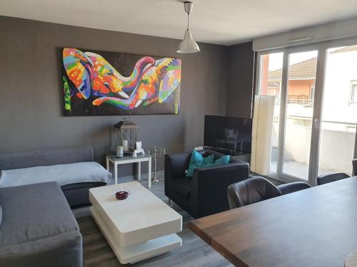 a living room with a couch and a table at Like home, in Geneva's neighborhood in Ville-la-Grand