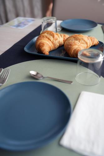 a table with blue plates and croissants on them at B&B Arco Dei Sogni in Celano